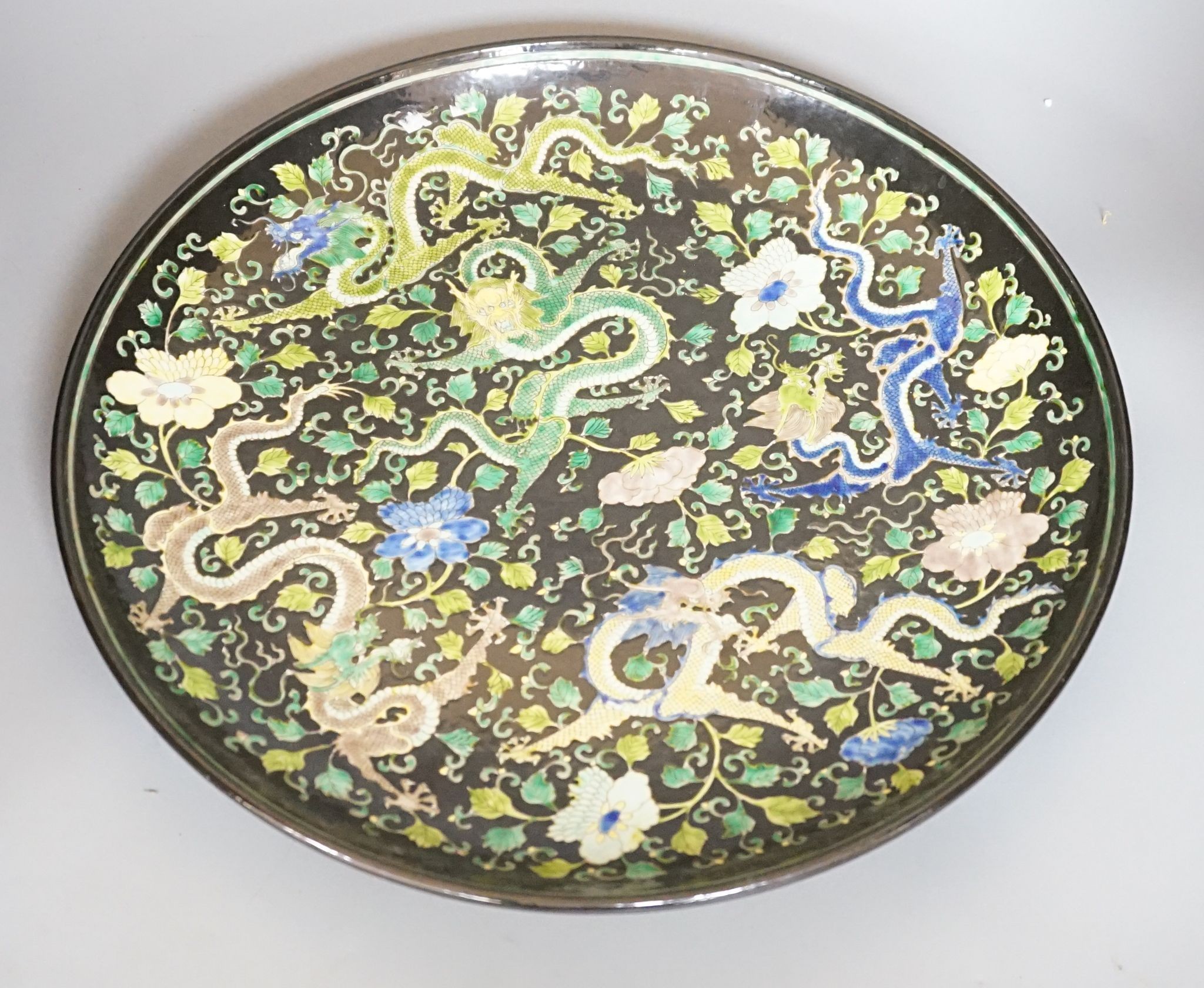 A large Chinese black ground 'dragon' dish, 43cm